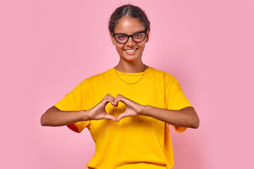 Young kind beautiful Indian woman student makes heart shape from fingers suggesting to pay...