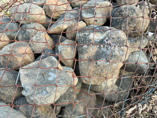 A closeup of stones in wired mesh to stop landslide on a mountain in India