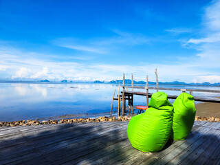 Bean bags chair on wooden balcony.