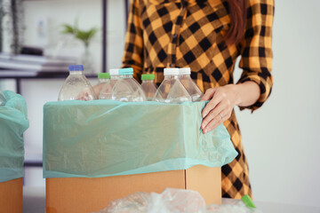 Women holding cardboard box of plastic bottle to reuse and recycling for sustainable environment