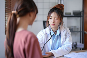 Asian psychologist women listening heartbeat of patient with stethoscope and giving counseling...