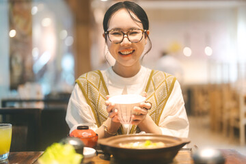 Happy asian woman holding rice bowl eating food at Japanese restaurant asia tasty from traditional culture