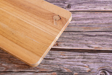 Wooden cutting board on rustic wooden background