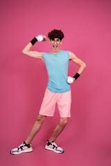Retro style. Funny curly guy doing aerobics in the style of the 80s. Pink background.