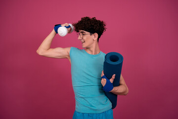 Obraz premium Retro style. Funny curly guy doing aerobics in the style of the 80s. Pink background.