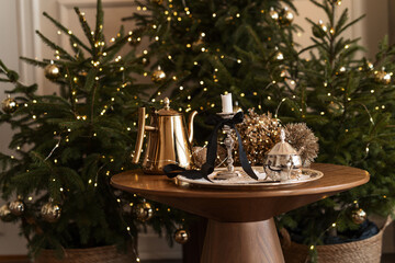 Christmas table setting with candles. Festive table with crockery near Christmas tree