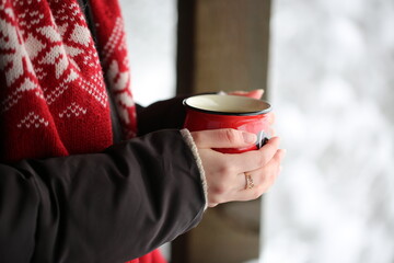 What can warm in the frozen? A mug of fragrant tea. The girl is holding a mug with hot tea. A very...