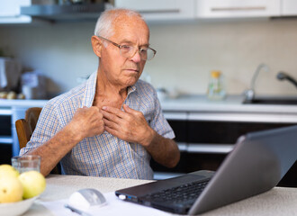 Man having video call with doctor, using laptop at home