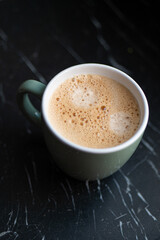 Tasse de café vue d'en haut posée sur une table en marbre noir