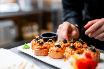 professional chef's hands making sushi roll in a restaurant kitchen