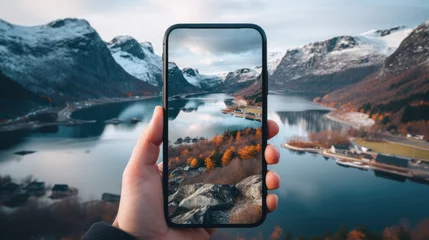 Fotobehang hand holding smartphone in the beautiful scenery with lake © hakule