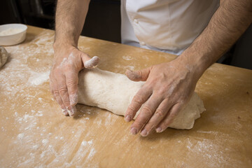 Fototapeta premium A baker prepares bread for baking
