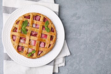 Delicious apple pie with mint on grey table, top view. Space for text
