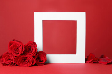 Stylish presentation for product. Frame, beautiful roses and petals on red background, space for text