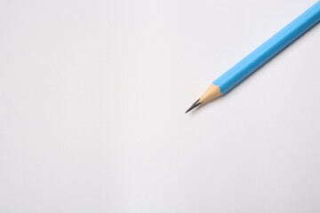 Sharp graphite pencil on white background, top view. Space for text