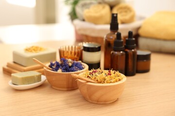 Dry flowers and soap bar on wooden table indoors. Spa time