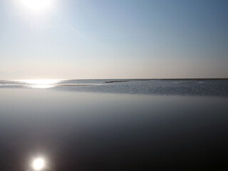 Lake Malawi, phot against the sun, calm water and blue sky, hazy