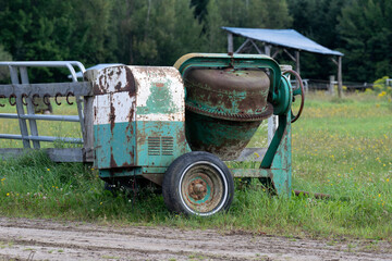 An old cement mixer abandoned in a field