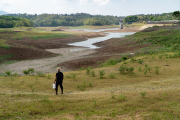 a man looks for water in the midst of the El-Nino climate disaster causing drought at the Palasari dam, Jembrana, Bali. The dam water receded and the land became dry and fragmented