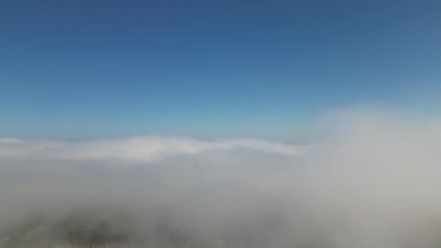 Drone Falling Through Low Clouds to an Urban Area