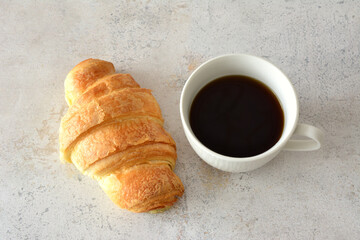 cup of strong black coffee and croissant top view 