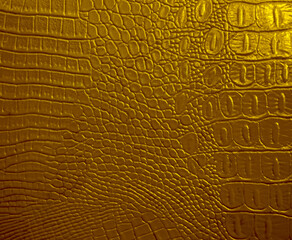 golden crocodile skin artificial leather with waves and folds on PVC base. mock up space. empty...