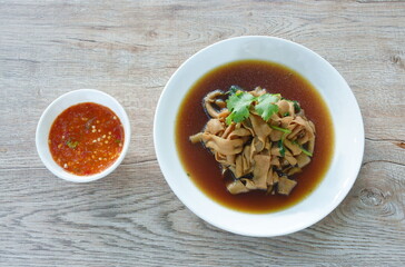 stewed duck intestine in brown soy soup on plate dipping spicy sauce 