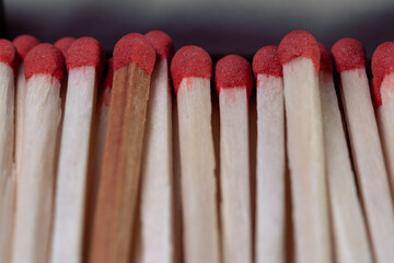 Lots of wooden matches with red sulfur heads closeup. Open box of matches. Matches in a cardboard box