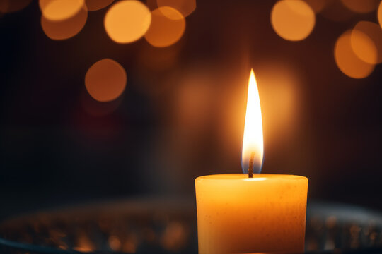 A close-up shot of a burning candle with soft, warm light