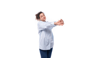 charming young brunette curly business woman in a blue shirt on a white background with copy space
