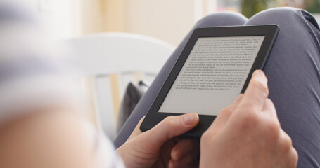 Woman reading an ebook on a reader with an e-ink display - 691055522