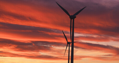 Windmill generating green energy by sunset at Neusiedl Weiden wind park in Austria