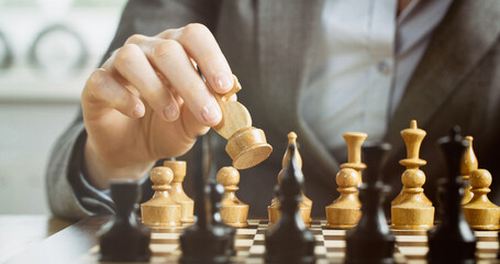 Chess player thinking about or making a move. Closeup photo, low angle.