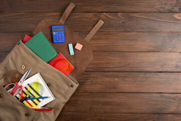 Back to school - books and school backpack on the desk in the auditorium, Education concept.