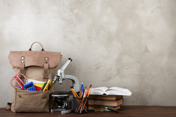 Back to school - books and school backpack on the desk in the auditorium, Education concept. - obrazy, fototapety, plakaty