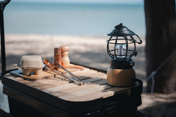 Camping essentials, a vintage kerosene lamp and a modern LED lantern on a wooden table. Enjoy...