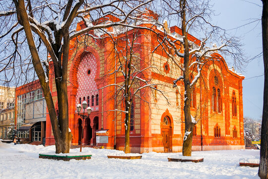 uzhgorod, ukraine - 05 FEB, 2010: red building of a former synagogue among leafless trees. winter cityscape in evening light
