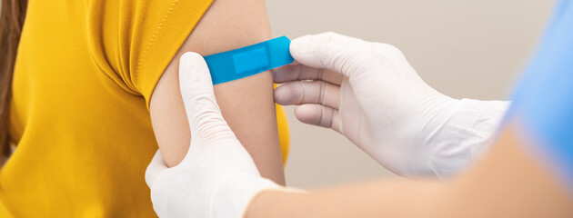 Vaccination coronavirus, hand of nurse apply plaster, bandage after doctor giving vaccine, injection dose on arm patient, immunization disease prevention against flu pandemic influenza, health care. - obrazy, fototapety, plakaty