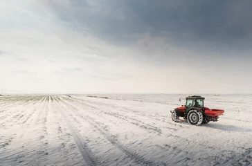 Fototapeten Farmer with tractor seeding - sowing crops at agricultural fields in winter © Dusan Kostic