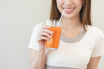 Orange detox juice, smile asian young woman hand holding a glass of vegetable juice, carrot...
