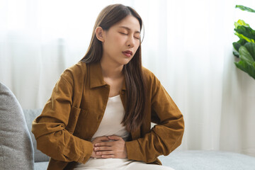 Flatulence asian young woman hand in stomach ache, suffer from food poisoning, abdominal pain and...