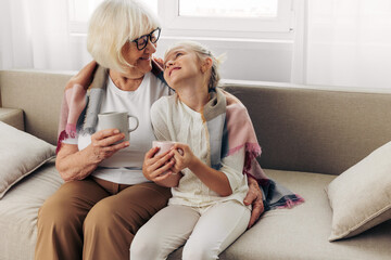 Love child plaid grandmother granddaughter girl sofa mugs hugging winter couch