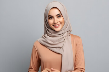 Young smiling confident arabian muslim woman in abaya hijab isolated on plain background studio portrait.