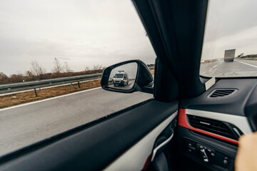 An ambulance vehicle in a rear view mirror. - obrazy, fototapety, plakaty