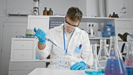 Handsome young caucasian scientist man, meticulously pouring liquid into test tubes in a high-tech...