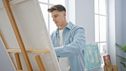 Handsome young caucasian man, deeply focused, drawing passionately in art studio, a glimpse into...