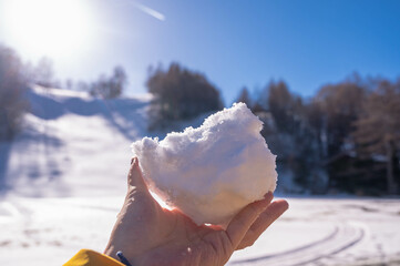 高原で雪玉を持つ女性の手　