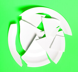 Broken white plate on a solid background