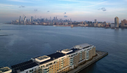 jersey city residential buildings on a pier in hudson river with midtown manhattan skyline in the...