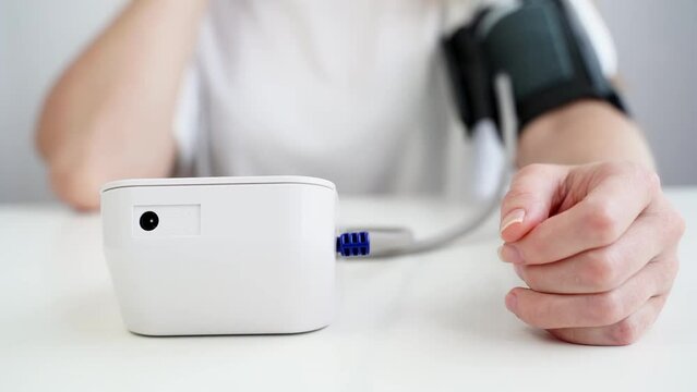 the girl measures blood pressure with a tonometer